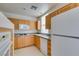 Kitchen featuring granite counters, double sinks, natural wood cabinets and modern appliances at 23 E Agate Ave # 303, Las Vegas, NV 89123