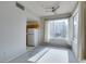 Bright living room with large windows and a ceiling fan, next to a functional kitchen space at 23 E Agate Ave # 303, Las Vegas, NV 89123