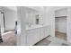 Modern bathroom with double vanity, walk-in shower, and entrance to a walk-in closet at 234 Walsh Peak Ave, Henderson, NV 89015