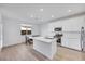 Bright kitchen boasts white cabinets, stainless appliances, an island, and a dining area with wood-look floors at 234 Walsh Peak Ave, Henderson, NV 89015