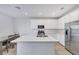 Modern kitchen features white cabinets, stainless steel appliances, and an island with a sink at 234 Walsh Peak Ave, Henderson, NV 89015