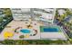 Aerial view of a condominium with tennis court, pool, yellow shade umbrellas and manicured lawns at 3111 Bel Air Dr # 15D, Las Vegas, NV 89109