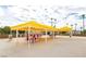 Outdoor dining area with many tables and chairs under yellow awnings and a few palm trees in the background at 3111 Bel Air Dr # 15D, Las Vegas, NV 89109