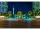Night shot of well-lit community entrance with lush landscaping and visible tower at 322 Karen Ave # 2206, Las Vegas, NV 89109