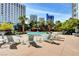 Resort-style pool area with palm trees, comfortable lounge chairs, and stunning views of the surrounding buildings at 322 Karen Ave # 2206, Las Vegas, NV 89109