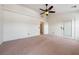 Spacious bedroom features neutral carpet, a ceiling fan, and a door leading to the backyard at 3581 Ranger Way, Pahrump, NV 89048