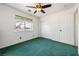 This charming bedroom features plush green carpet, a ceiling fan, and a bright window at 3581 Ranger Way, Pahrump, NV 89048