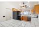 Kitchen with black refrigerator, tiled counters, and oak cabinets at 3581 Ranger Way, Pahrump, NV 89048