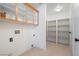 Convenient laundry room with built-in shelves and cabinets for storage, plus washer and dryer hookups at 3581 Ranger Way, Pahrump, NV 89048