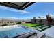 Backyard hot tub has a waterfall feature, a lounging area, and views beyond the backyard fence at 394 Red Feather Peak Ct, Las Vegas, NV 89138