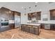 Modern kitchen with dark wood cabinets, stainless steel appliances, and large center island at 394 Red Feather Peak Ct, Las Vegas, NV 89138