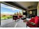 Inviting outdoor living space with comfortable seating, a ceiling fan, and views of the manicured backyard at 394 Red Feather Peak Ct, Las Vegas, NV 89138