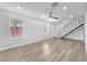 Open-concept living area boasts wood-look floors, a ceiling fan, and staircase access to the upper level at 3946 Torsby Pl # 3946, Las Vegas, NV 89119
