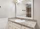 Bathroom vanity with a granite countertop, offering a view into the tiled shower/tub area at 3986 Visby Ln, Las Vegas, NV 89119
