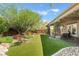 Expansive backyard featuring artificial turf, decorative rock, and a covered patio for relaxing and entertaining at 4014 Trapani Pl, Las Vegas, NV 89141