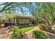 Lush backyard featuring artificial turf, landscaping, and charming covered patio at 4014 Trapani Pl, Las Vegas, NV 89141