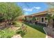 Inviting backyard with artificial grass, mature trees, and a covered patio perfect for outdoor living at 4014 Trapani Pl, Las Vegas, NV 89141