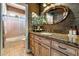 Charming bathroom with a granite countertop, vanity, patterned wallpaper and a shower over tub at 4014 Trapani Pl, Las Vegas, NV 89141