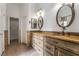 Bathroom with double vanity, decorative mirrors and lighting, and neutral paint at 4014 Trapani Pl, Las Vegas, NV 89141