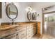 Bathroom with double vanity, decorative mirrors and lighting, and neutral paint at 4014 Trapani Pl, Las Vegas, NV 89141
