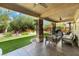 Relax in the expansive covered patio with ceiling fans and ample seating, overlooking the lush backyard at 4014 Trapani Pl, Las Vegas, NV 89141