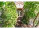 Charming home entrance with lush, green foliage framing the walkway and double glass doors at 4014 Trapani Pl, Las Vegas, NV 89141
