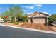 Charming single-story home with a well-maintained, wide driveway leading to multiple garage doors and mature desert landscaping at 4014 Trapani Pl, Las Vegas, NV 89141