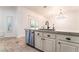 Kitchen island featuring a stainless steel dishwasher and neutral color cabinets and stone countertops at 4014 Trapani Pl, Las Vegas, NV 89141