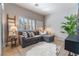 Cozy living room with a sectional sofa, plush rug, plantation shutters, and a modern decor at 4014 Trapani Pl, Las Vegas, NV 89141