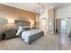 Relaxing primary bedroom with a large bed, textured wall covering, and an elegant lighting fixture at 4014 Trapani Pl, Las Vegas, NV 89141