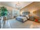 Serene primary bedroom featuring a decorative light fixture, neutral walls, and large windows for ample natural light at 4014 Trapani Pl, Las Vegas, NV 89141
