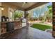 Enjoy this outdoor kitchen with a grill, mini refrigerator and a dining set with an amazing backyard view at 4014 Trapani Pl, Las Vegas, NV 89141