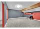Gray carpet in open basement with beam ceiling, painted in gray and red at 4414 E Baltimore Ave, Las Vegas, NV 89104