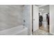 Modern bathroom featuring marble tiled shower, bathtub, and a doorway to the laundry area at 4414 E Baltimore Ave, Las Vegas, NV 89104