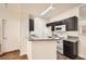 Compact kitchen with white appliances, granite counters, and dark cabinetry at 5162 S Jones Blvd # 108, Las Vegas, NV 89118