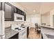 Galley kitchen featuring granite countertops, white appliances, and an adjacent dining area at 5162 S Jones Blvd # 108, Las Vegas, NV 89118