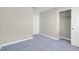 A cozy bedroom has neutral walls, plush blue carpeting, and a closet with a door and hanging rod at 5305 La Patera Ln, Las Vegas, NV 89149