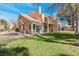 Charming two-story home features a well-maintained lawn, a private balcony, and a tile roof under a clear blue sky at 5305 La Patera Ln, Las Vegas, NV 89149