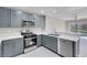 Updated kitchen with stainless steel appliances and sink, as well as gray cabinets and white countertops at 5305 La Patera Ln, Las Vegas, NV 89149