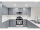 Updated kitchen featuring stainless steel appliances, white countertops, and gray cabinets at 5305 La Patera Ln, Las Vegas, NV 89149