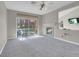 Bright living room with a fireplace, ceiling fan, and sliding glass doors to the outside patio at 5305 La Patera Ln, Las Vegas, NV 89149