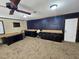 Basement featuring tan carpet, a ceiling fan, storage, and black and tan walls, offers versatile space at 5350 Topaz St, Las Vegas, NV 89120