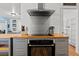A kitchen cooktop and oven under a stainless hood with wood counters and gray cabinets at 5350 Topaz St, Las Vegas, NV 89120