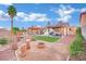 Backyard featuring a decorative rock border, bridge, synthetic lawn, and covered patio at 585 Jackson Dr, Henderson, NV 89014