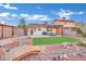 Landscaped backyard featuring decorative rock, a bridge, synthetic lawn, and covered patio at 585 Jackson Dr, Henderson, NV 89014