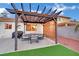 Backyard patio featuring a covered seating area, BBQ, and a synthetic lawn at 585 Jackson Dr, Henderson, NV 89014