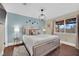 Stylish bedroom with queen bed, modern light fixture, and blue accent wall at 585 Jackson Dr, Henderson, NV 89014