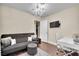 Another view of the cozy bedroom space with a gray sofa, workspace, and ceiling chandelier at 585 Jackson Dr, Henderson, NV 89014