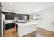 Bright kitchen features an island with quartz countertop, stainless steel appliances and dark cabinetry at 6844 Bayou Hollow Ave, Las Vegas, NV 89156