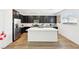 Bright kitchen features an island with quartz countertop, stainless steel appliances and dark cabinetry at 6844 Bayou Hollow Ave, Las Vegas, NV 89156